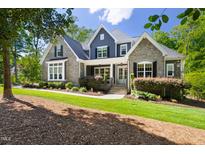 Charming two-story home with stone and shingle siding, manicured lawn, and inviting front porch at 30 Ocoee Falls Dr, Chapel Hill, NC 27517