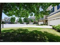 View of a well-maintained street showing multiple homes with manicured lawns and attached garages at 306 Mainline Station Dr, Morrisville, NC 27560