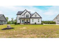 Charming two-story home with a well-manicured lawn and welcoming front porch at 474 Pine Ridge Rd, Zebulon, NC 27597
