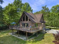 Side view of the home with large deck and stone facade at 506 Burgess Rd, Apex, NC 27523