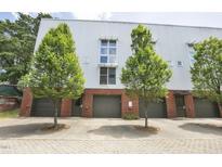 Modern townhome featuring metal siding, brick accents, individual garages and landscaped trees at 506 N Mangum St # 402, Durham, NC 27701