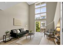 Bright living room boasts soaring windows, neutral color palette, and an open and airy feel at 506 N Mangum St # 402, Durham, NC 27701