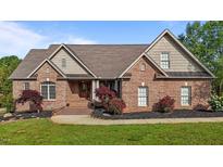 Beautiful brick home with manicured lawn and landscaped flower beds, exuding curb appeal at 5250 Sartin Rd, Burlington, NC 27217