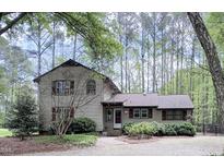 Charming two-story home with red shutters and a landscaped front yard, enveloped by tall trees at 5728 Carriagehouse Ct, Apex, NC 27539