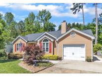 Charming single-Gathering home with attached garage, well-maintained landscaping, and an American flag at 5909 Royal Coach Ct, Raleigh, NC 27612