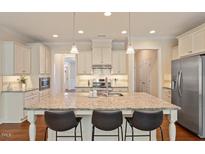 Bright kitchen features a granite island with seating and stainless steel appliances at 704 Long Lake Dr, Fuquay Varina, NC 27526