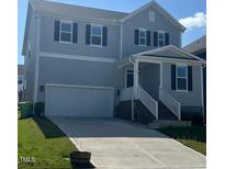 Charming two-story home with light gray siding, a two-car garage, and manicured front lawn at 712 Emmer St, Rolesville, NC 27571