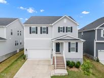 Charming two-story home featuring a gray exterior, black shutters, and a well-manicured front yard at 712 Emmer St, Rolesville, NC 27571