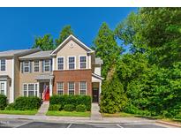 Charming townhome featuring a mix of brick and siding with a well-manicured lawn and mature trees at 7761 Winners Edge St, Raleigh, NC 27617