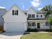 Charming two-story home featuring a two-car garage, black shutters, and a welcoming front porch at 808 Trinity Park Dr, Wake Forest, NC 27587