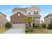 Charming two-story home with a brick facade, attached garage, and professionally landscaped front yard at 844 Cozy Oak Ave, Cary, NC 27519