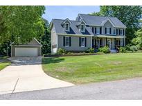 Charming two-story home with mature trees, a detached garage, and a beautifully manicured lawn at 8517 Falkirk Ridge Ct, Wake Forest, NC 27587