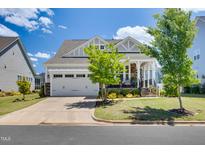 Charming home featuring a two-car garage and inviting front porch with stone accents at 94 Two Creeks, Chapel Hill, NC 27517