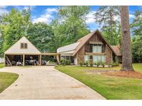 Charming home with stone and wood exterior, featuring an attached garage and lush landscaping at 1003 W Divine St, Dunn, NC 28334