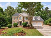 Charming two-story brick home with a well-manicured lawn, mature trees, and an attached two-car garage at 108 Nimbus Ct, Cary, NC 27513