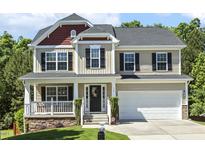 Charming two-story home featuring a welcoming front porch and well-maintained landscaping at 109 Lyngrove St, Holly Springs, NC 27540