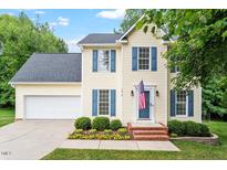 Charming two-story home featuring blue shutters, a well-manicured lawn, and an attached two-car garage at 1614 Finnsbury Dr, Burlington, NC 27217