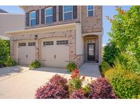 Beautiful two-story brick home featuring a two-car garage, black shutters, and well manicured landscaping at 1904 Birdhouse Ln, Wake Forest, NC 27587