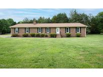 Charming single-story brick home with a large front yard and well-maintained landscaping at 201 E Laramie Dr, Mebane, NC 27302