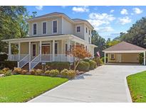 Charming two-story home featuring a classic porch, manicured lawn, and detached garage at 207 N Hopkins Ave, Spring Hope, NC 27882