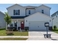 Charming two-story home featuring a red front door, a two-car garage, and a well-manicured lawn at 2238 Cherry Creek Rd, Haw River, NC 27258