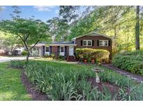 Charming brick home with lush landscaping, healthy green lawn, and decorative walkway at 241 E Cornwall Rd, Cary, NC 27511