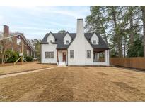 Beautifully renovated two-story home with white exterior, black roof, and manicured front yard at 2515 W Club Blvd, Durham, NC 27705