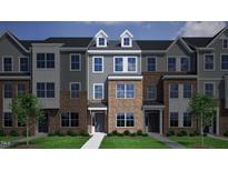 Charming townhome showcases a brick and siding exterior with well-maintained landscaping at 352 Chesapeak Commons St # 136, Garner, NC 27529