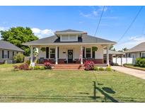 Charming home featuring a brick front porch, lawn, and cozy seating, inviting relaxation and curb appeal at 404 W E St, Erwin, NC 28339