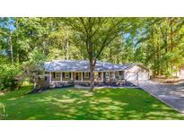 Aerial view of a beautiful single-story brick home with a well-manicured lawn and mature trees at 4901 Old Elizabeth Rd, Raleigh, NC 27616