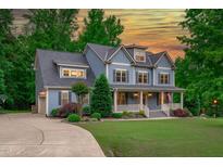 Charming two-story blue home with a welcoming front porch and well-manicured lawn at 6509 Duncans Creek Ct, Fuquay Varina, NC 27526