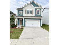 Inviting two-story home with blue siding, white trim, shuttered windows, and a two-car garage at 67 Commons Cir, Clayton, NC 27520