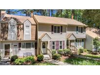 Charming townhouse with tan siding, manicured landscaping, and inviting front entryways at 704 Benchmark Dr, Raleigh, NC 27615