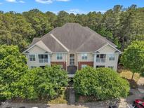 Beautiful exterior view of tan and red brick building with mature trees and blue skies above at 711 Providence Glen Dr, Chapel Hill, NC 27514