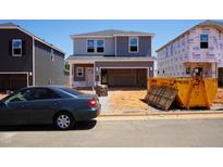 New two-story home with gray siding, visible construction materials, and an unfinished yard at 809 Ottawa Dr, Garner, NC 27529