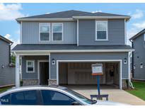 Two-story home featuring a two-car garage, horizontal siding, and a front yard at 809 Ottawa Dr, Garner, NC 27529
