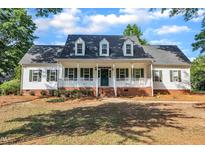 Charming two-story traditional home with dormers, white siding, and a welcoming front porch at 8113 Huskfield Ct, Apex, NC 27539