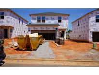 New home construction site featuring house with Tyvek wrap, yellow dumpster, and materials at 829 Ottawa Dr, Garner, NC 27529