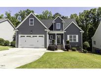 Charming home featuring a two-car garage, gray siding and manicured landscaping at 870 Live Oak Ln, Nashville, NC 27856
