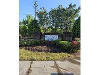 Entrance to Hanover Pointe featuring a brick sign surrounded by manicured landscaping and lush greenery at 1030 Thoughtful Spot Ln, Durham, NC 27703