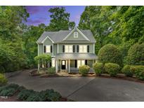 Charming two-story home with a well-manicured lawn, inviting porch, and mature landscaping at 104 Windorah Place Pl, Chapel Hill, NC 27517