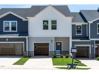 New construction townhome with a garage, modern design, and a well-manicured lawn at 1043 Winding Spring Dr, Mebane, NC 27302