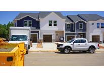 New construction townhomes featuring two-tone color schemes and attached garages at 1043 Winding Spring Dr, Mebane, NC 27302