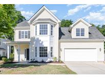 Inviting two-story home with a two-car garage, bay window and manicured lawn and yellow siding at 1148 Dexter Ridge Dr, Holly Springs, NC 27540
