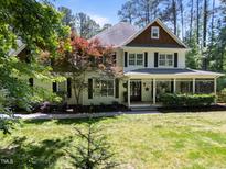 Charming two-story traditional-style home featuring a cozy front porch and well-manicured lawn and mature trees at 120 Harmony Hill Ln, Cary, NC 27513