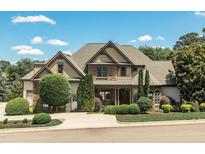 Two-story home featuring stone and siding with a well-manicured lawn and mature landscaping at 12317 Richmond Run Dr, Raleigh, NC 27614