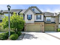 Charming townhome features a two-car garage, stone accents, and well-manicured landscaping at 140 Sunstone Dr, Cary, NC 27519