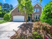 Charming brick home with a two-car garage, manicured landscaping, and a welcoming front entrance at 1719 Willowcrest Rd, Durham, NC 27703