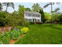 Charming two-story home with black shutters and a lush green lawn and well-manicured landscaping at 1904 Victoria Rd, Raleigh, NC 27608