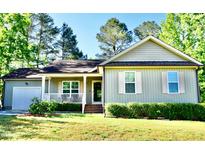 Charming single-story home with a well-manicured lawn, cozy front porch and attached garage at 1980 Ferbow St, Creedmoor, NC 27522
